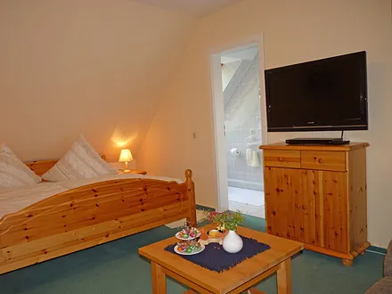 Sideboard mit Wand-Flachbildschirm (90° schwnekbar) und Eingang zum angrenzenden Duschbad