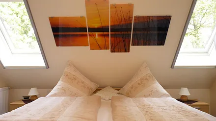 Buchungsoption: 2. Schlafzimmer im DG gelegen (ca. 12,5 m²), Zugang erfolgt über Treppe zum DG (via Küche), ist ausgestattet mit einem Ehebett inkl. beids. NS, 2 Fenster inkl. Jalousie & Insektenrollo