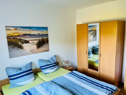 Das Elternschlafzimmer verfügt über ein großes Doppelbett und einen Kleiderschrank.