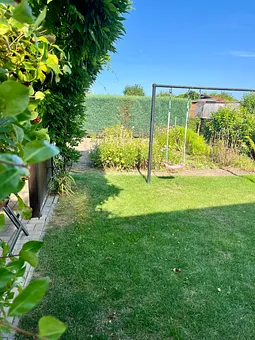 Der Garten mit Schaukel und überdachte Sitzmöglichkeit