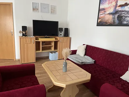 Das Wohnzimmer mit Essbereich ist mit einem großen Fernseher und einer CD-Anlage ausgestattet.