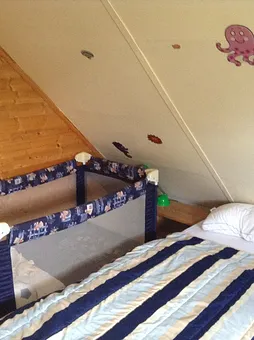 Im oberen Schlafraum bieten wir neben einem Doppelbett und einem separaten Bett ein Reisebett für Kleinkinder.