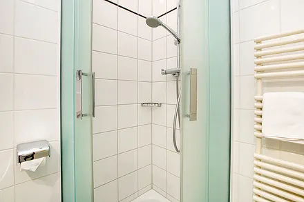 ... mit Dusche, Handtuchtrockner und WC.