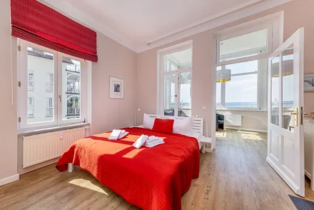 Der komfortable Doppelbett und der Blick in die Loggia.