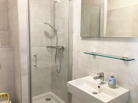 Das moderne Bad mit Dusche und WC.