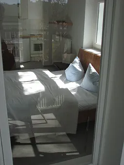 Blick vom Wintergarten in das Appartement D302. Das Licht spiegelt die Ausssicht auf die andere Straßenseite.
