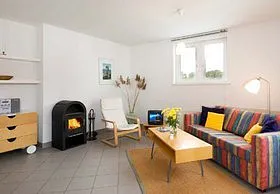 Wohnen unterm Dach: Das Wohnzimmer hat eine Kaminecke und ein Sofa, das sich auch als Bett nutzen lässt.