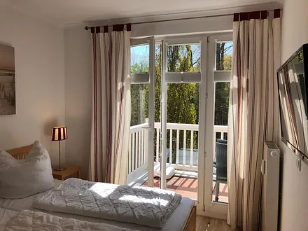 Blick auf den Balkon vom Schlafzimmer mit TV