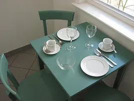 Der kleine Esstisch steht in der abgeteilten Küche. Sie finden dort alles nötige, um Speisen fast wie zuhause zubereiten zu können - ganz unabhängig von Restaurantzeiten.