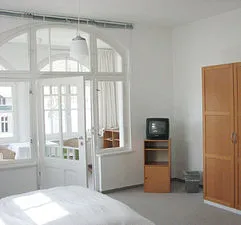 Die 1 Zi.-FW hat einen separaten Wintergarten mit Sitzecke. Im Hauptraum gibt es auch einen Schreibtisch.