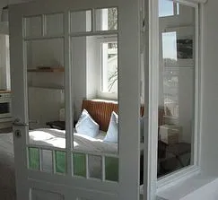 Ein historisches Rundbogenelement trennt den Hauptraum vom Wintergarten.