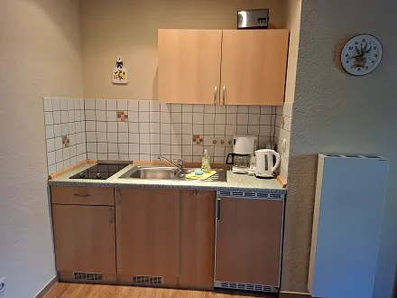 Die Küchenzeile mit Kaffeemaschine, Toaster und Wasserkocher.
