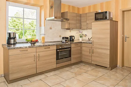 Vollausgestattete Küche mit Backofen, Geschrirrspüler, Kühlschrank und Mircrowelle