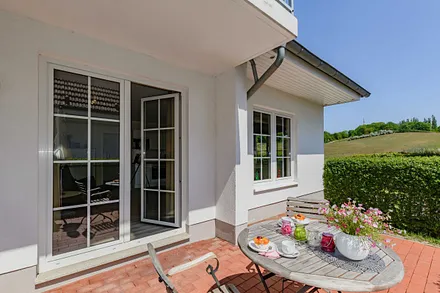 bestuhlte Terrasse durch eine Hecke geschützt