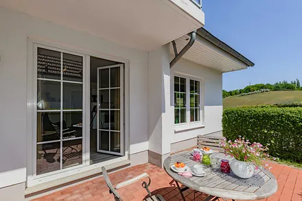 bestuhlte Terrasse durch eine Hecke geschützt