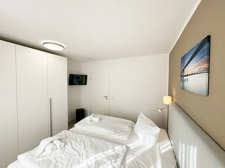 Schlafzimmer mit Kleiderschrank und TV