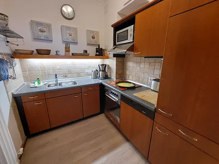 Die separate Küche besticht durch eine komfortable Ausstattung mit Induktionskochfeld, Backofen, Geschirrspüler und Kühlschrank mit Gefrierfach