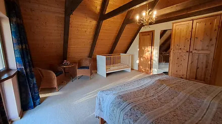 Schlafzimmer mit Sitzecke und Kinderbett