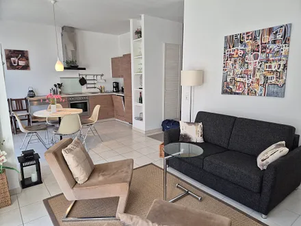 Wohnbereich mit Schlafsofa und komplett eingerichteter Küche