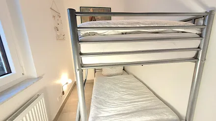 kleines Kinderzimmer mit Doppelstockbett und Schrank