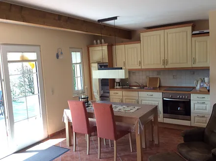 Wohnküche mit Herd, Geschirrspüler und großem Esstisch