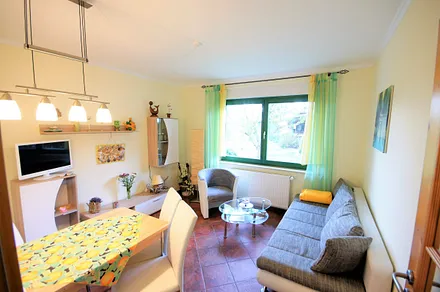 Wohnzimmer mit Schlafcouch und Essecke