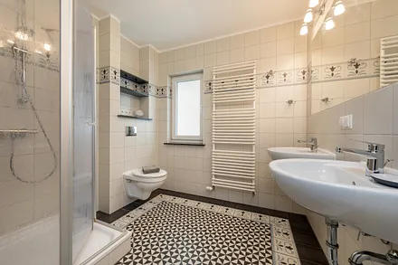 Das schöne Bad hat 2 Waschbecken, Dusche, WC, Fußbodenheizung und Handtuchtrockner.