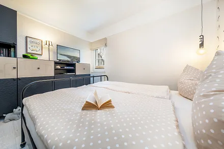 ... ein TV-Gerät, DVD-Player und ein Fenster mit Verdunkelungsgardinen und Plissee.