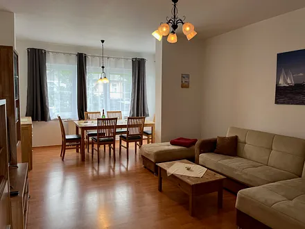 Wohnzimmer mit Sitzgruppe im Erker und Schlafcouch