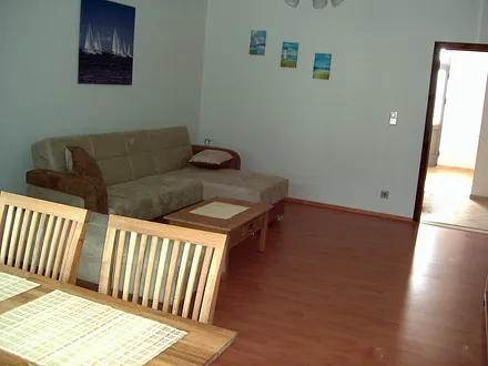 Wohnzimmer mit Schlafcouch und Erker mit Eßecke