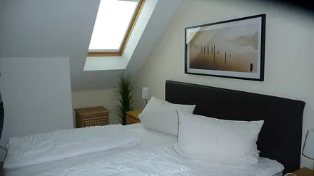 1 Schlafzimmer mit Doppelbett und Bettwäsche