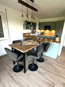 Esstisch mit Küchenzeile im Hintergrund