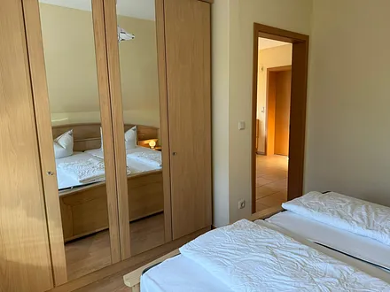Schlafzimmer mit Bettanlage und Spiegelkleiderschrank