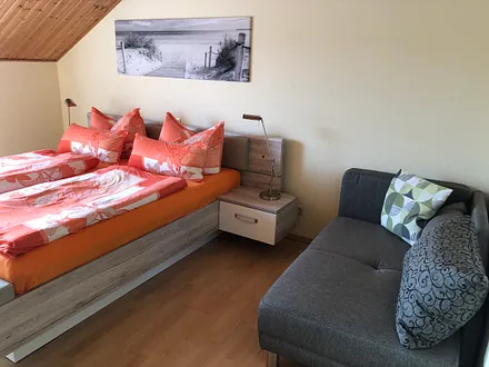 Schlafzimmer mit Doppelbett und Schlafsofa für ein Kind