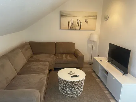 Wohnzimmer mit Ecksofa und TV