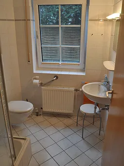 Blick ins Badezimmer mit Dusche, WC und Waschbecken