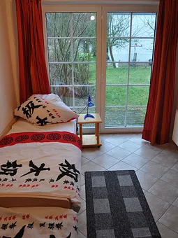 Zweites Schlafzimmer mit zwei Betten, Schrank und Stühlen