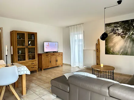 großzügiges Wohnzimmer mit Esstisch und TV