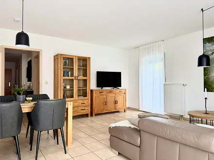 großzügiges Wohnzimmer mit Esstisch und TV