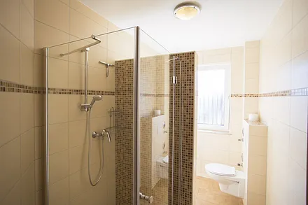 Bad mit ebenerdiger Dusche und Fenster