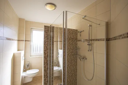 Bad mit ebenerdiger Dusche und Fenster