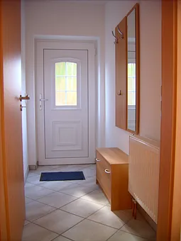 Die Ferienwohnung verfügt über einen eigenen Eingang. Im separaten Flur befindet sich eine Garderobe mit Spiegel und ein Schuhschrank.