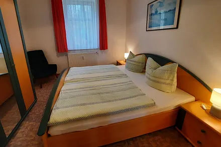 Schlafzimmer mit Doppelbett und Sessel