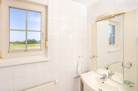Badezimmer mit Dusche und WC sowie Unterschrank