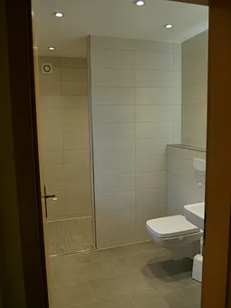 Das Badezimmer verfügt (neben Tageslicht und Fön) über eine offene, begehbare Dusche und ist 2022 komplett neu gefliest.