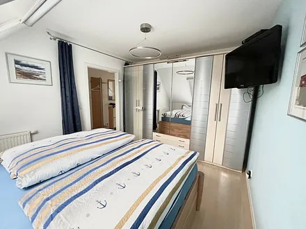 Blick ins Schlafzimmer zum großen Kleiderschrank und Flachbild-TV