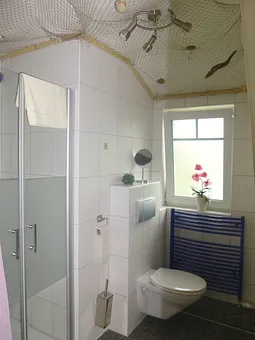 Badezimmer mit Dusche und Handtuchtrockner über Fußbodenheizung