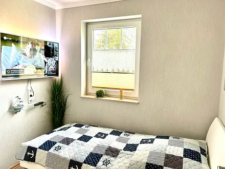 Kinderzimmer mit Einzelbett und Fernseher