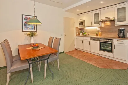 vollausgestattete Küchenzeile mit Esstisch