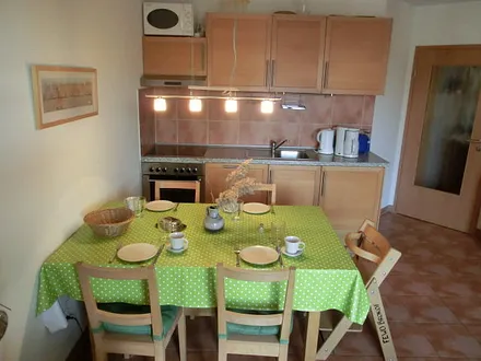 Eß- und Küchenbereich mit zusätzlich ausziehbarem Tisch und 5 Stühlen. Der auf dem Foto sichtbare Hochstuhl gehört zur Wohnung.